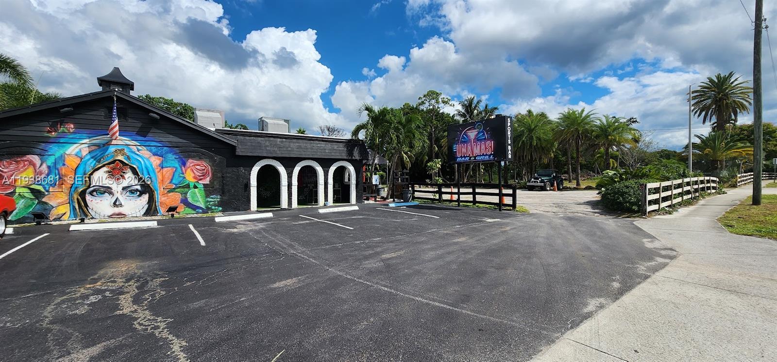 A black building features a large mural of a woman and a sports bar sign — 3801 N 10th Ave N, Palm Springs FL 33461, PALM SPRINGS, FL