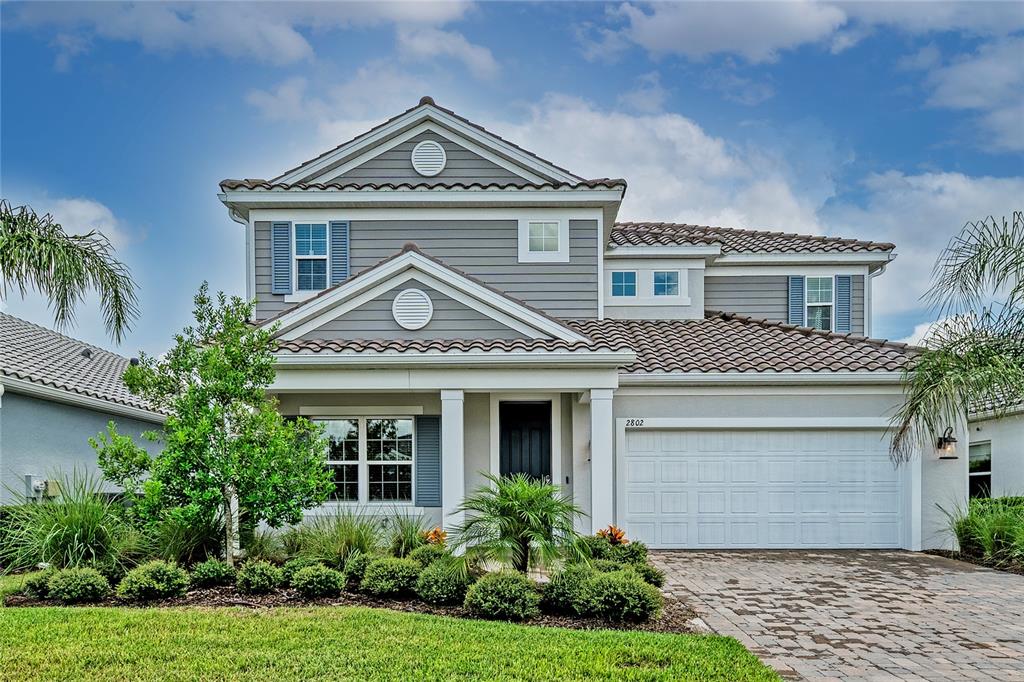 A two-story house with gray siding, a tiled roof, and a two-car garage — 2802 BUTTERFLY JASMINE TRAIL, SARASOTA, FL