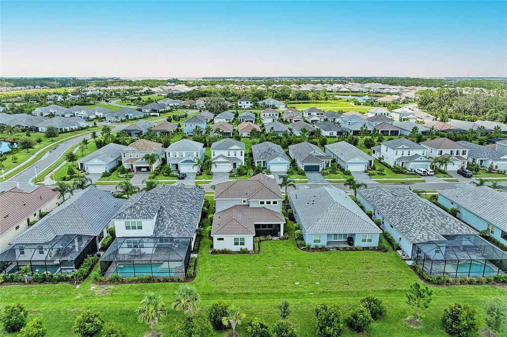 An aerial view shows a suburban neighborhood with several single-family homes and private swimming pools — 2802 BUTTERFLY JASMINE TRAIL, SARASOTA, FL