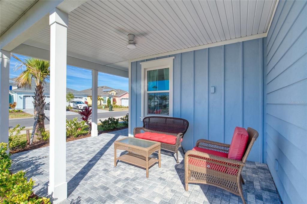 A covered front porch features light blue vertical siding, a paved floor, and wicker furniture — 198 GYPSY PALACE LANE, DAYTONA BEACH, FL