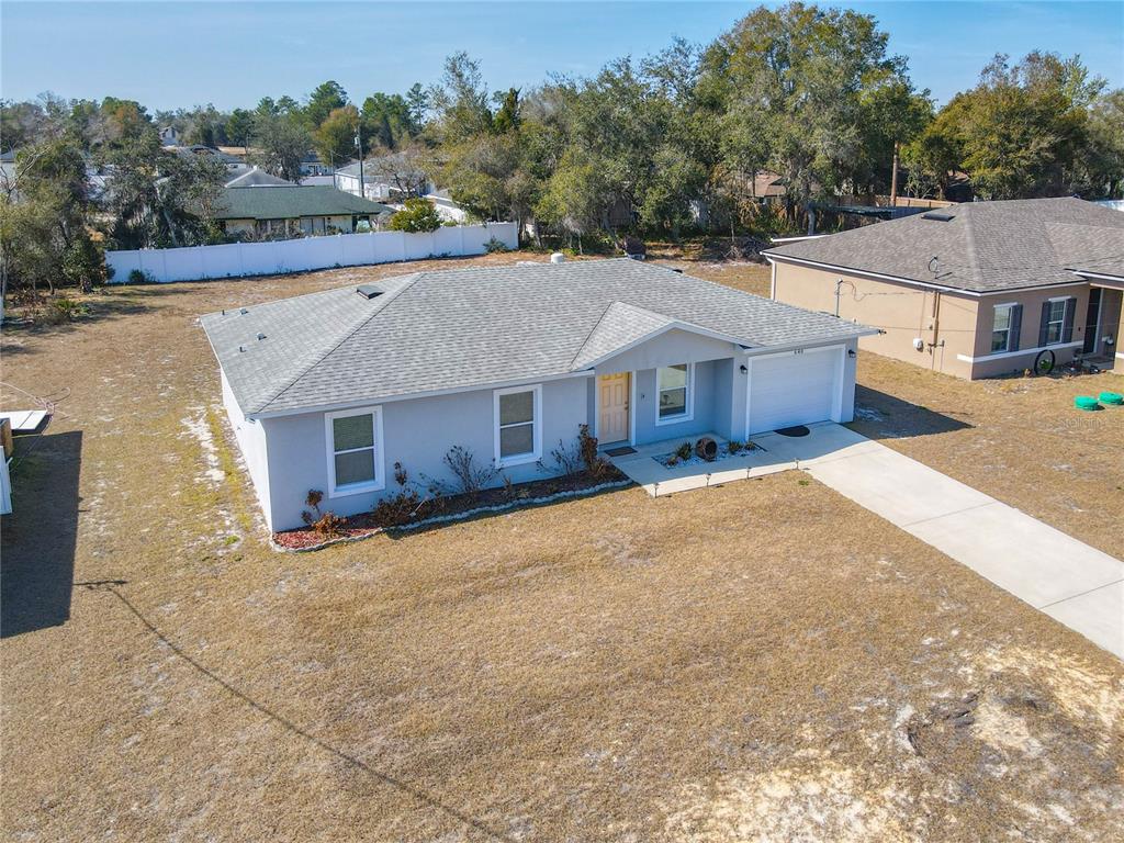 An aerial view shows a single-story gray house with a white garage and shingled roof — 640 CHESTNUT AVENUE, ORANGE CITY, FL