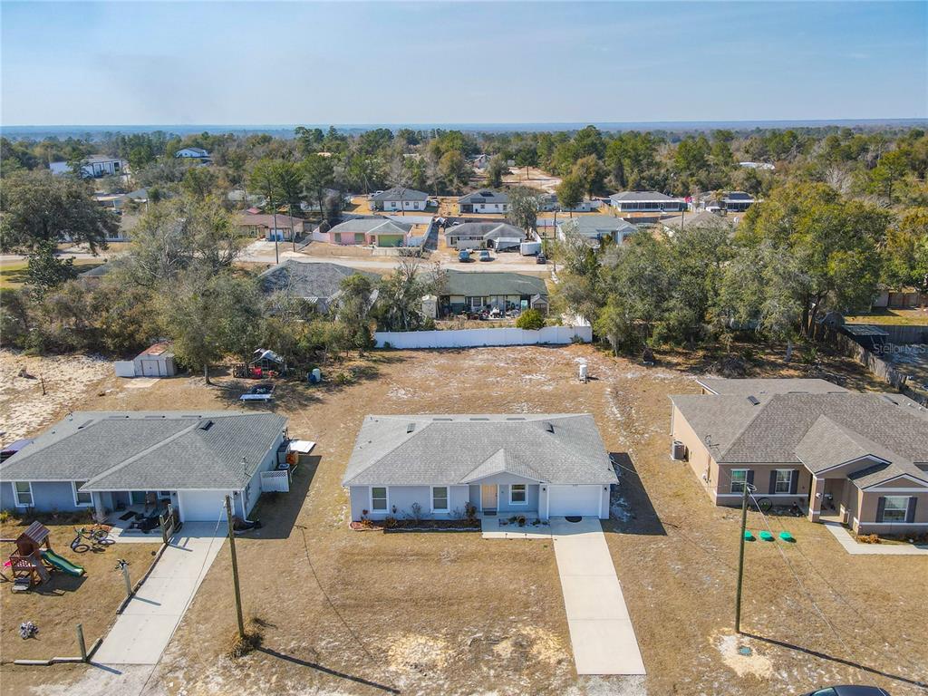 An aerial view shows three single-story houses with driveways and a large vacant lot — 640 CHESTNUT AVENUE, ORANGE CITY, FL