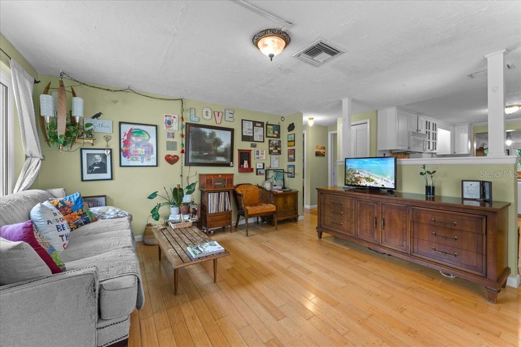 A living room features light green walls, hardwood floors, a gray sofa, and a wooden console — 531 6TH STREET S, SAFETY HARBOR, FL