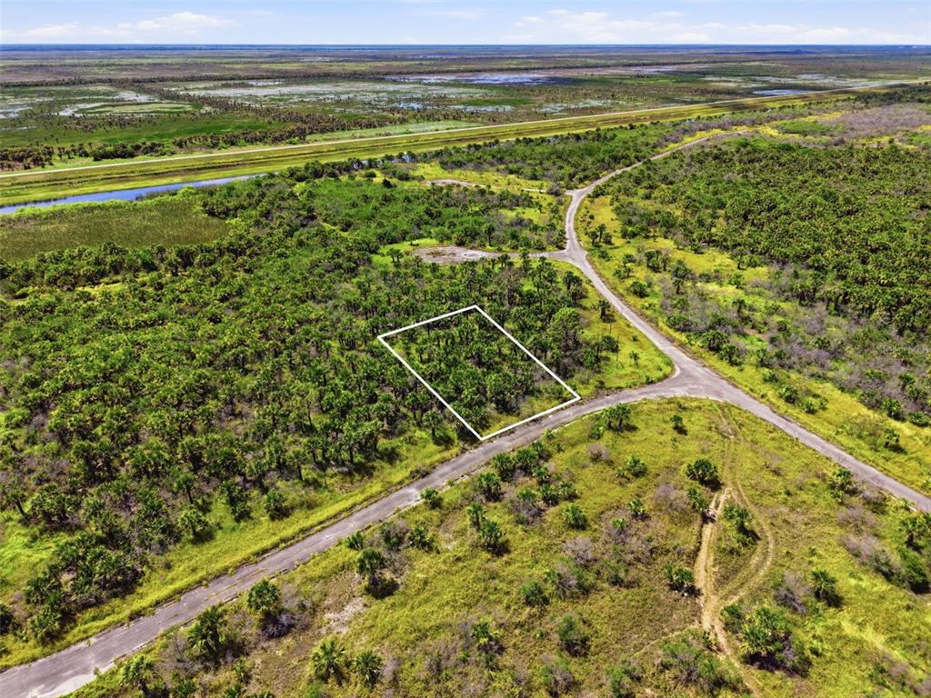 An aerial view shows a rectangular plot of land outlined in white near a road — 2806 FLAMEFLOWER TERRACE SW, PALM BAY, FL