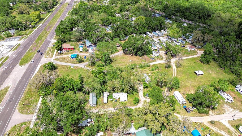 An aerial view shows a rural property with multiple mobile homes, trees, and a nearby highway — 19140 US HIGHWAY 301, DADE CITY, FL