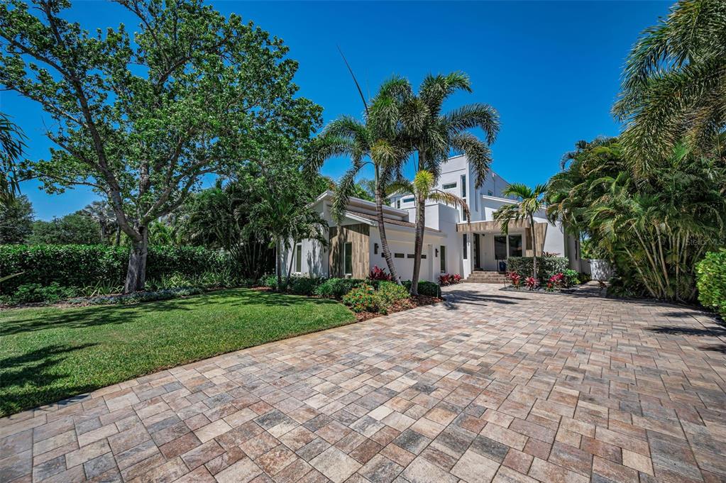 A bright living room features high ceilings, dark wood floors, and a modern chandelier — 1710 BRIGHTWATERS BOULEVARD NE, ST PETERSBURG, FL
