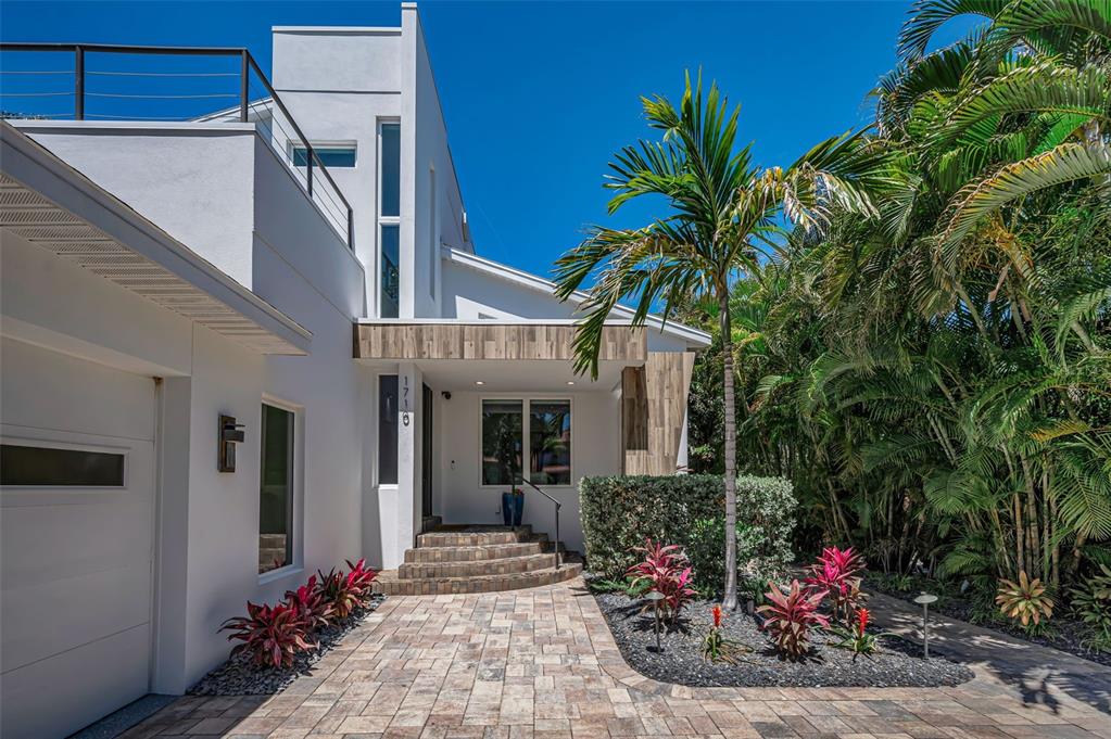 A kitchen island with a stone countertop sits in front of a dining area — 1710 BRIGHTWATERS BOULEVARD NE, ST PETERSBURG, FL