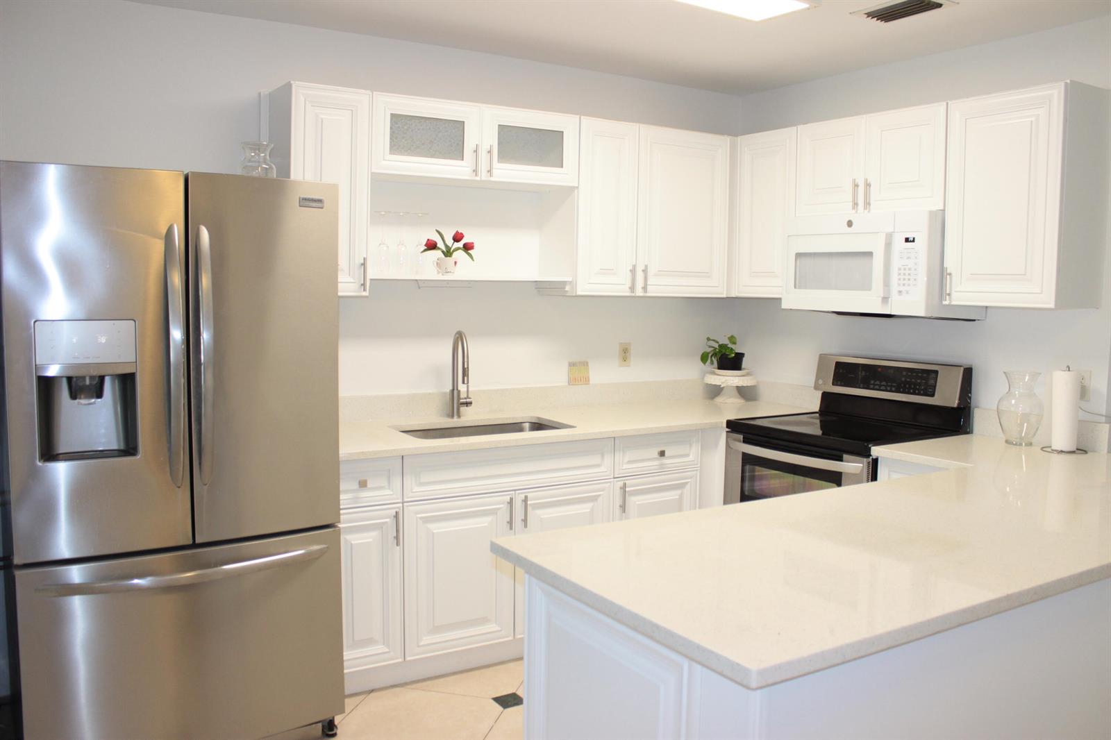 A kitchen with white cabinets, stainless steel appliances, and light-colored countertops — 8573 Boca Drive # 3, Boca Raton FL 33433, BOCA RATON, FL