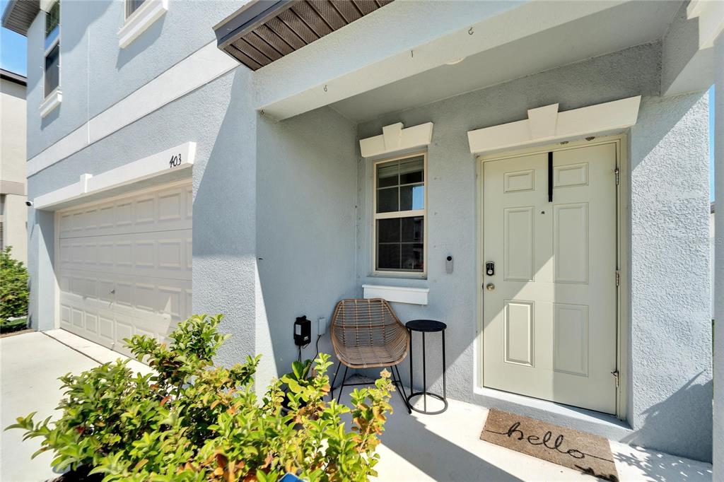 The exterior of a house features a garage, a front door, and a small porch — 403 ROYAL EMPRESS DRIVE, RUSKIN, FL