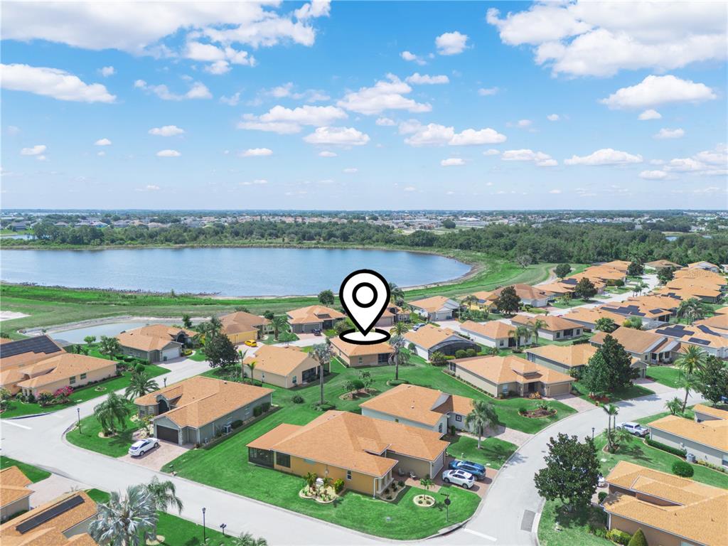 An aerial view shows a suburban neighborhood with single-family homes situated near a large lake — 5308 GREEN DRIVE, WINTER HAVEN, FL