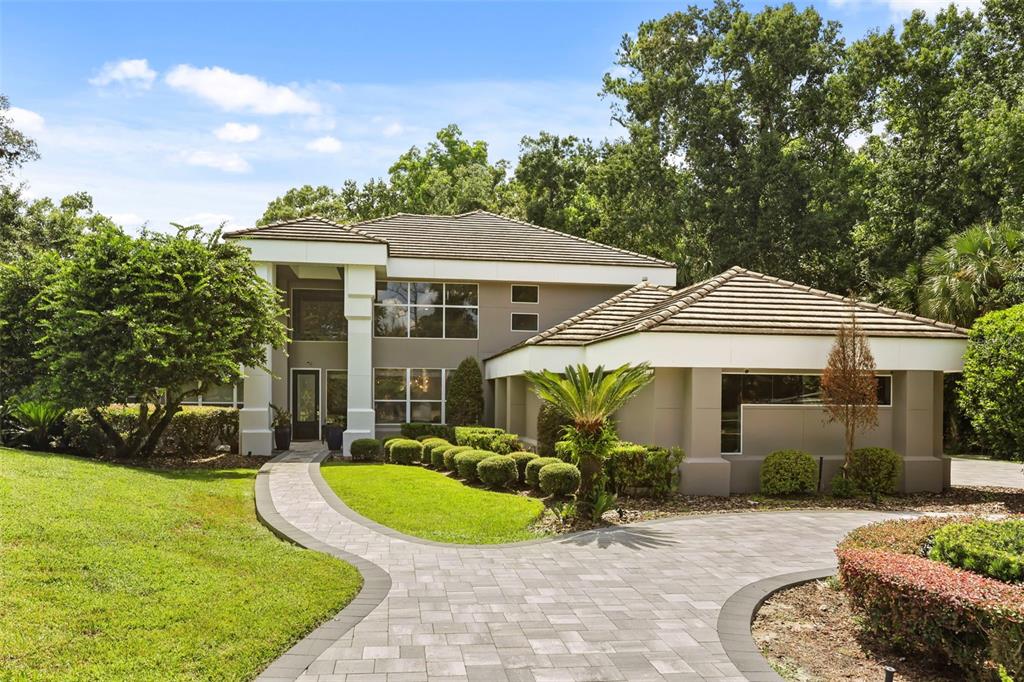 A two-story house with a paved walkway, a tile roof, and a landscaped front yard — 359 VISTA OAK DRIVE, LONGWOOD, FL