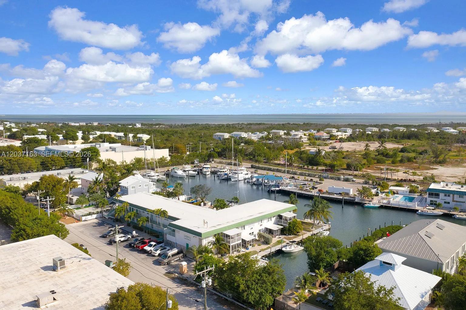An aerial view shows a waterfront apartment complex with a boat marina and parking lot — 5301 Ocean Ter # 1, Marathon FL 33050, MARATHON, FL