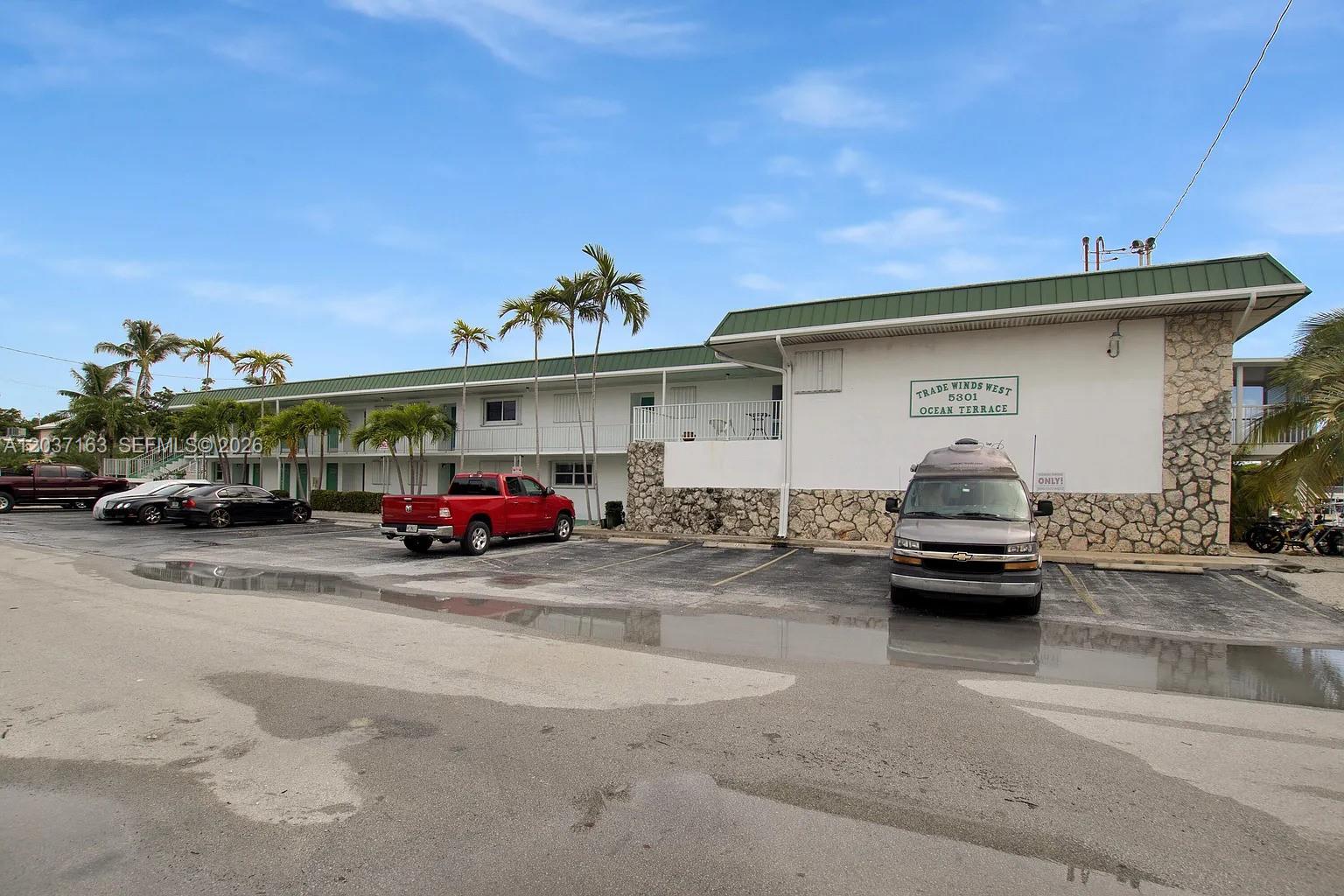A two-story apartment building with a stone facade and a parking lot in front — 5301 Ocean Ter # 1, Marathon FL 33050, MARATHON, FL