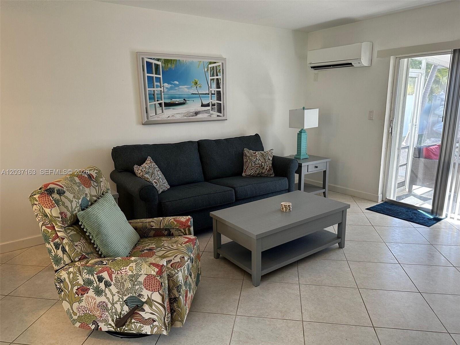 A living room features a dark sofa, a patterned armchair, and a gray coffee table — 5301 Ocean Ter # 1, Marathon FL 33050, MARATHON, FL