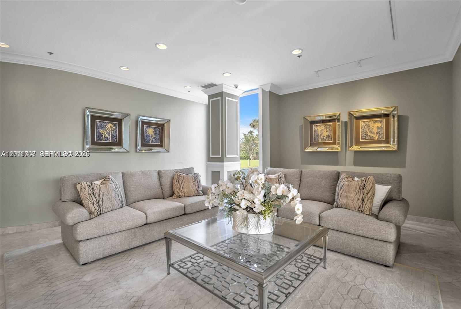 A living room features two grey sofas, a glass coffee table, and four framed artworks — 5510 N Ocean Dr # 19B, Singer Island FL 33404, SINGER ISLAND, FL