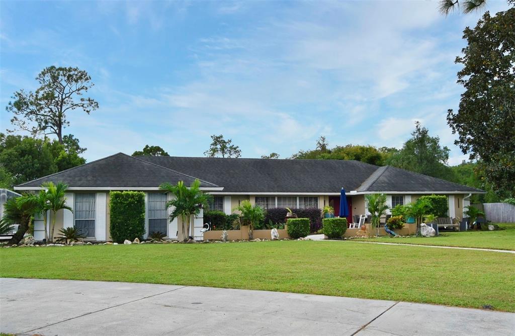 A single-story ranch-style house with a dark roof, light siding, and a landscaped front yard — 1200 WAVERLY WAY, LONGWOOD, FL