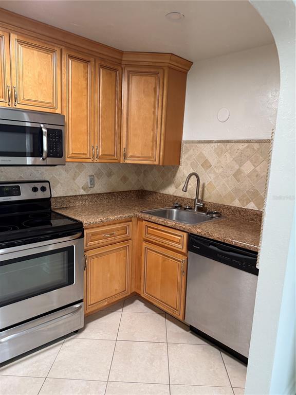 A kitchen features wood cabinets, stainless steel appliances, granite countertops, and a tiled backsplash — 1317 35TH AVENUE N, ST PETERSBURG, FL