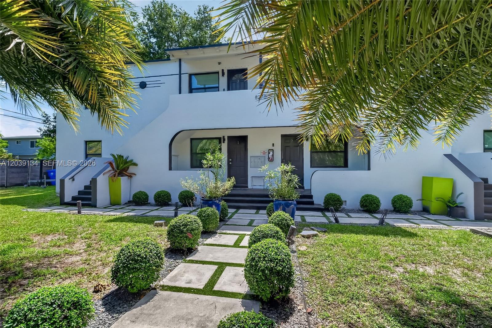 A two-story white apartment building features a landscaped front yard with a stone walkway — 8270 NE 1st Pl # 3, Miami FL 33138, MIAMI, FL