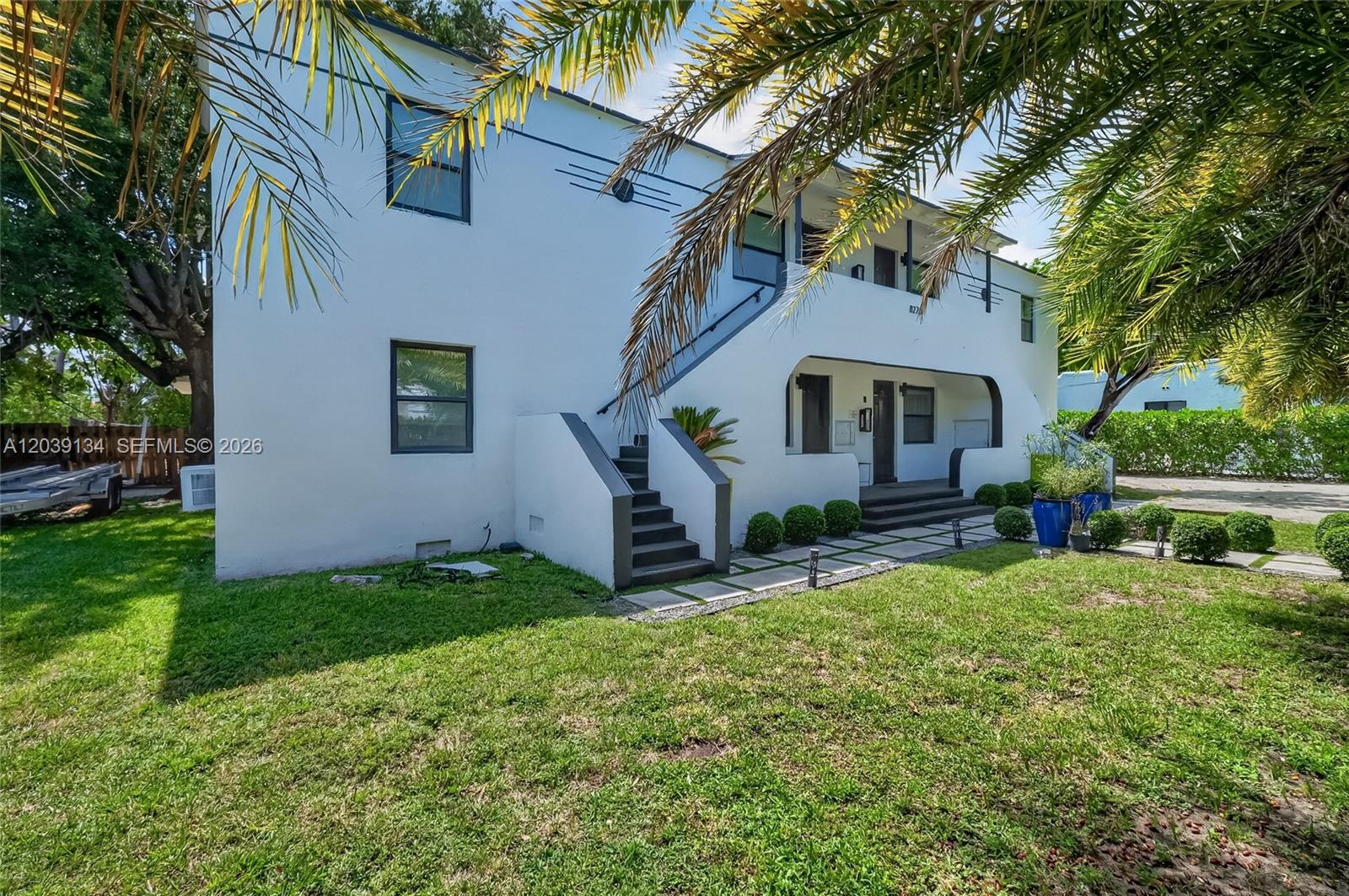 A two-story white building features an exterior staircase and a landscaped front lawn — 8270 NE 1st Pl # 3, Miami FL 33138, MIAMI, FL
