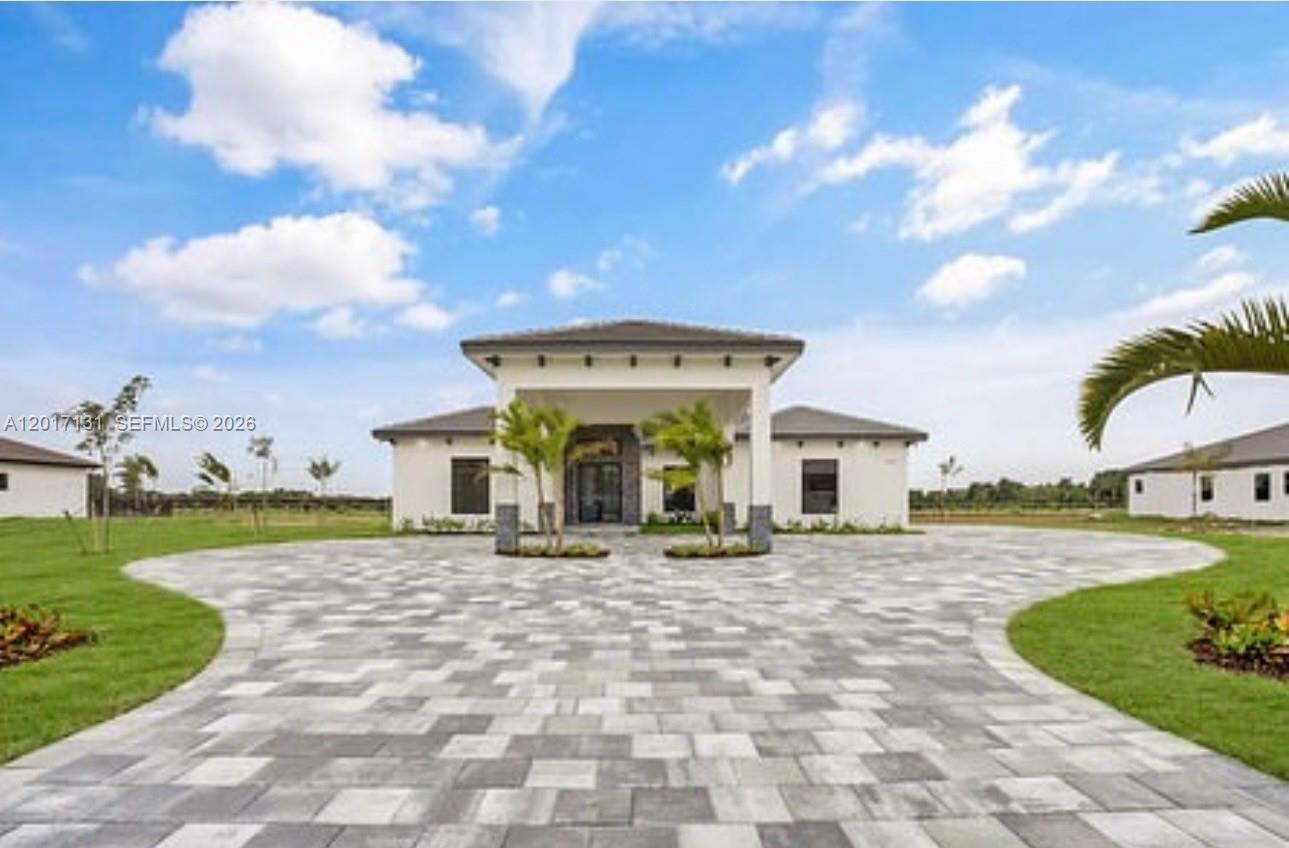 A modern, single-story house with a large paved driveway and a covered entryway — sw 246 sw 187 Ave, Miami FL 33031, MIAMI, FL