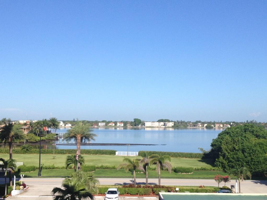 An elevated view of a calm lake surrounded by trees, buildings, and a grassy lawn — 3450 S Ocean Boulevard # 3280, Palm Beach FL 33480, PALM BEACH, FL