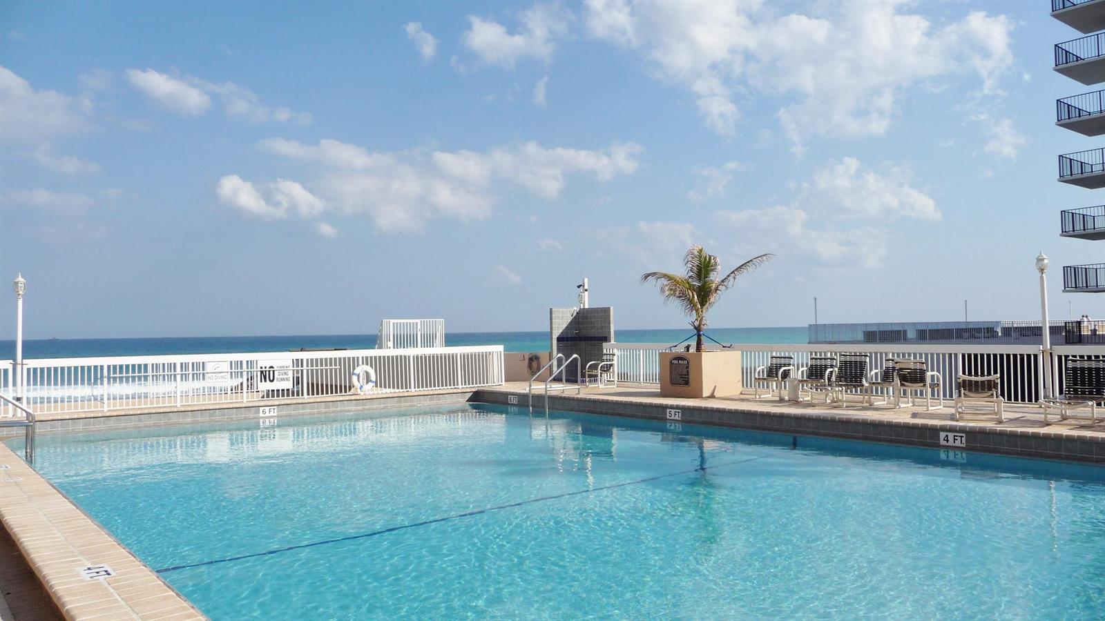 An outdoor swimming pool overlooks the ocean with lounge chairs on the deck — 3450 S Ocean Boulevard # 3280, Palm Beach FL 33480, PALM BEACH, FL