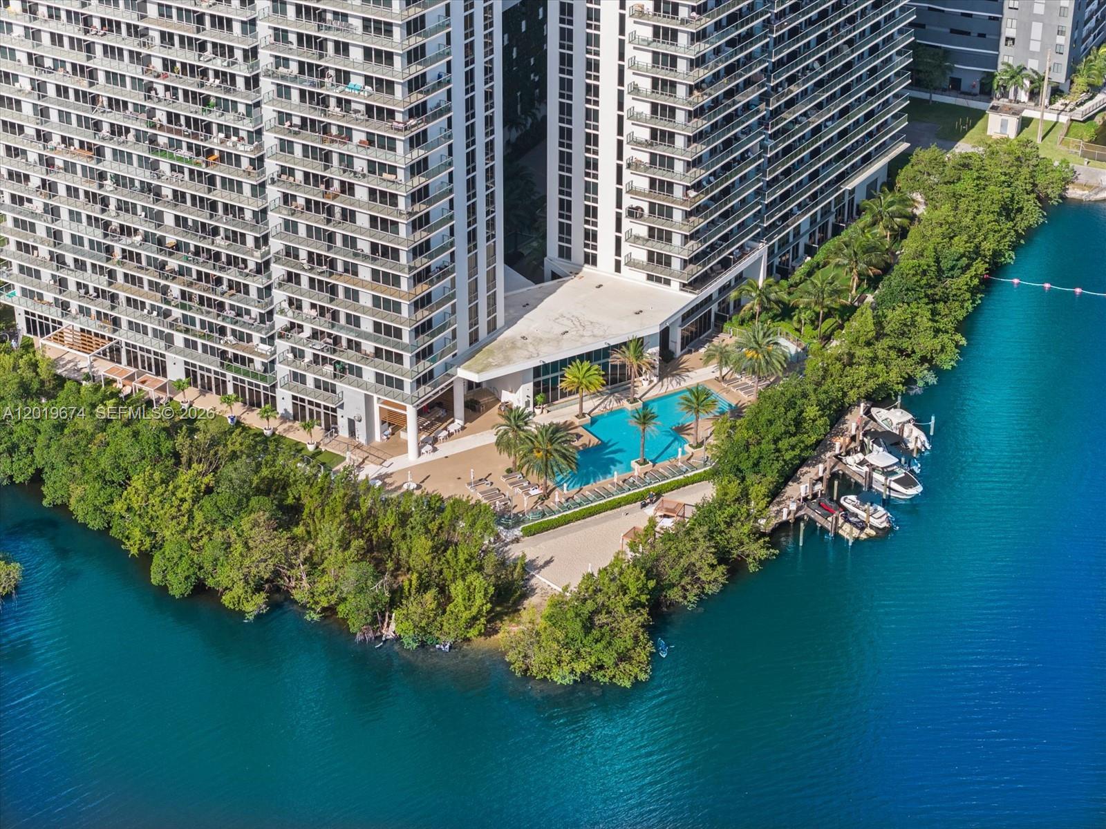 An aerial view shows a high-rise apartment building with a pool deck and boat docks — 16385 Biscayne Blvd # 3103, North Miami Beach FL 33160, NORTH MIAMI BEACH, FL