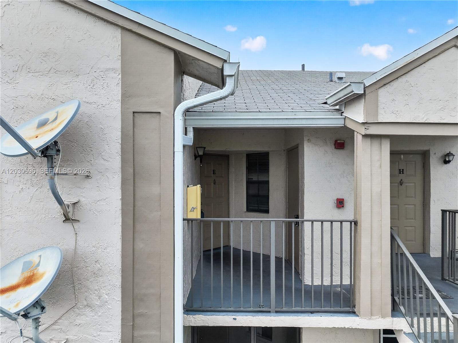 An exterior view shows two apartment doors labeled E and H with a shared balcony — 889 Hamilton Dr # 889E, Homestead FL 33034, HOMESTEAD, FL