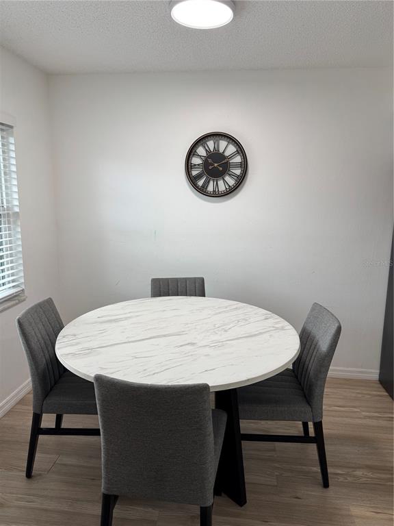 A dining area features a round white marble-topped table with four grey upholstered chairs — 2342 BARBADOS COURT, KISSIMMEE, FL