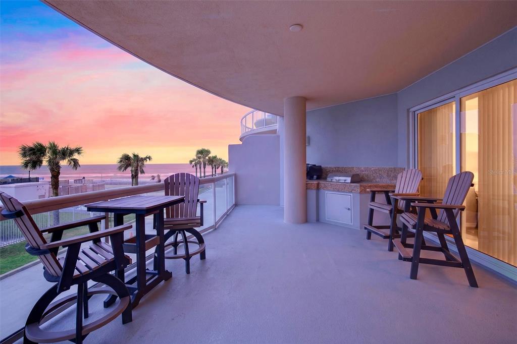 A covered balcony features outdoor furniture, a built-in grill, and a view of the ocean — 3703 S ATLANTIC AVENUE UNIT 204, DAYTONA BEACH SHORES, FL
