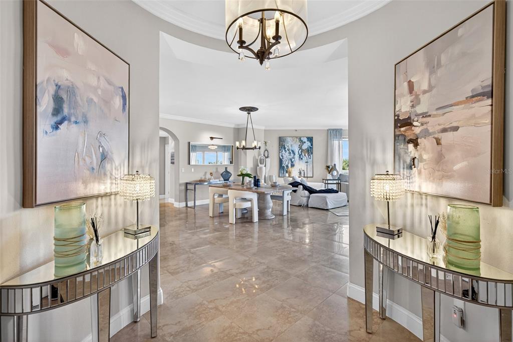 A symmetrical entryway with mirrored console tables leads into an open-concept dining and living area — 3703 S ATLANTIC AVENUE UNIT 204, DAYTONA BEACH SHORES, FL