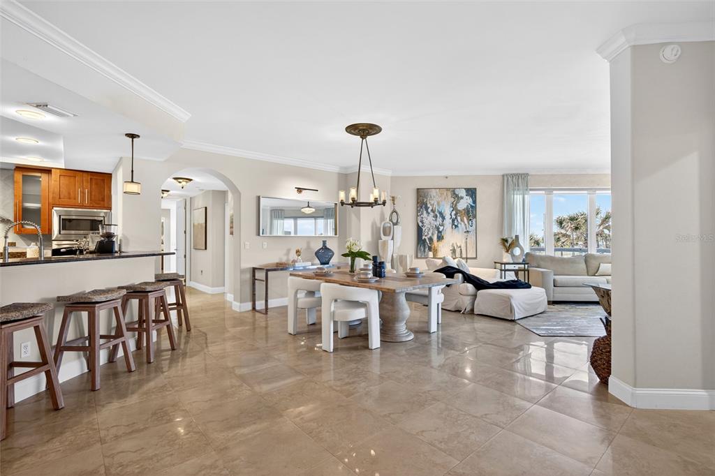 An open-concept living and dining area features tile flooring, a kitchen island, and large windows — 3703 S ATLANTIC AVENUE UNIT 204, DAYTONA BEACH SHORES, FL