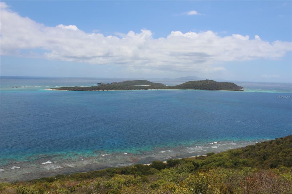 A high-angle view shows a tropical island surrounded by blue ocean and a coastal shoreline — 250 Zoni PLAYA LARGA, CULEBRA, PR