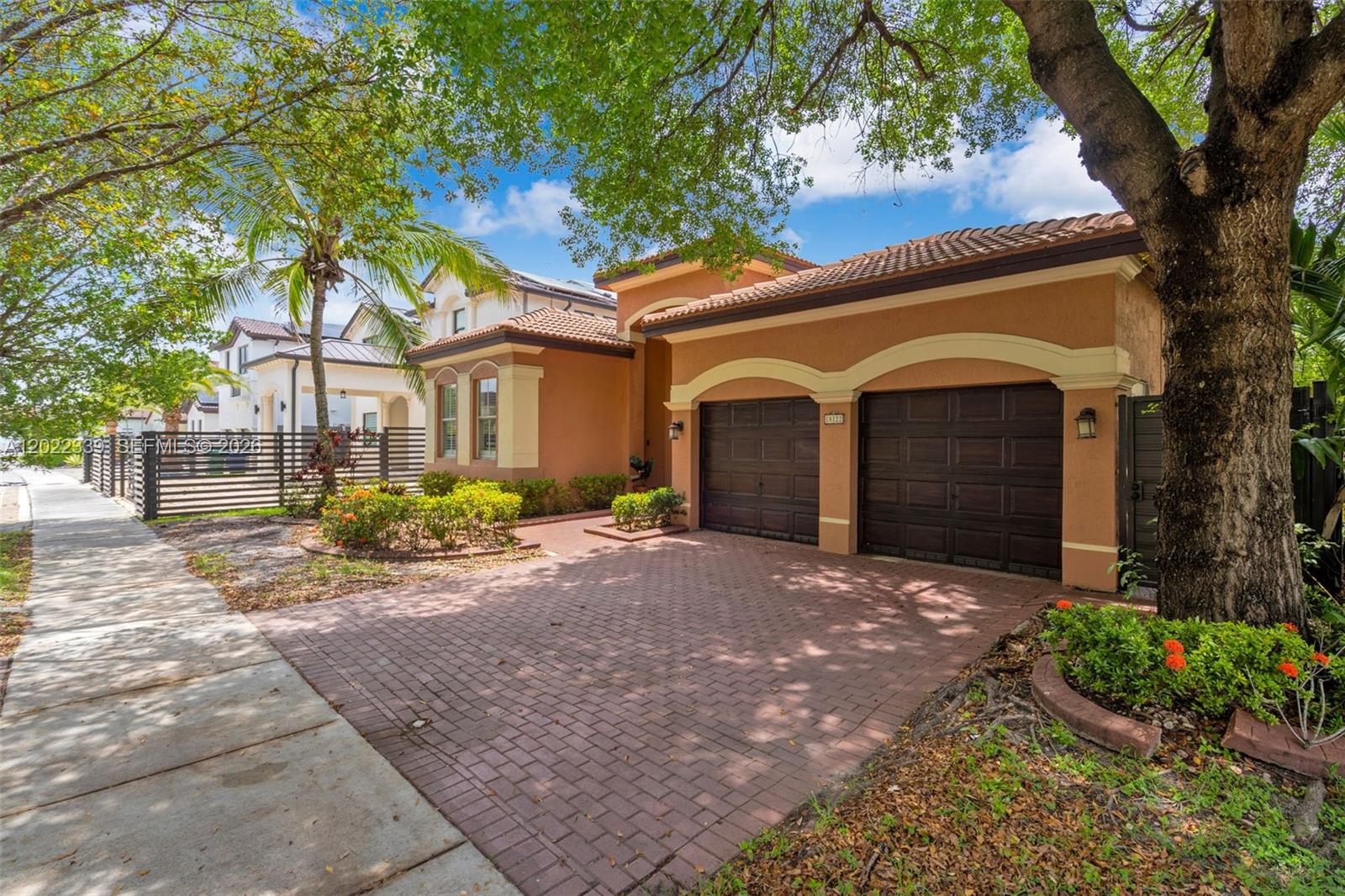 A two-story stucco house features a two-car garage and a brick paver driveway — 18122 NW 91st Ct, Hialeah FL 33018, HIALEAH, FL