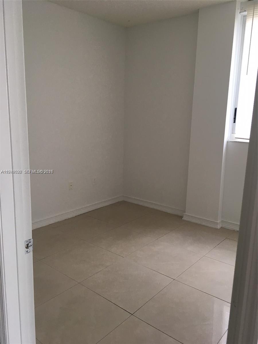 This is a small, empty room with white walls and light-colored tile flooring — 5091 NW 7th St # 602, Miami FL 33126, MIAMI, FL