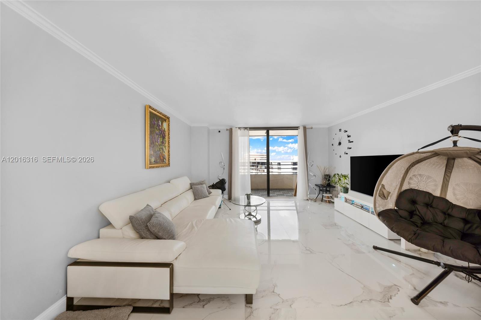 A living room features white marble floors, a white sectional sofa, and a hanging chair — 2500 Parkview Dr # 2119, Hallandale Beach FL 33009, HALLANDALE BEACH, FL