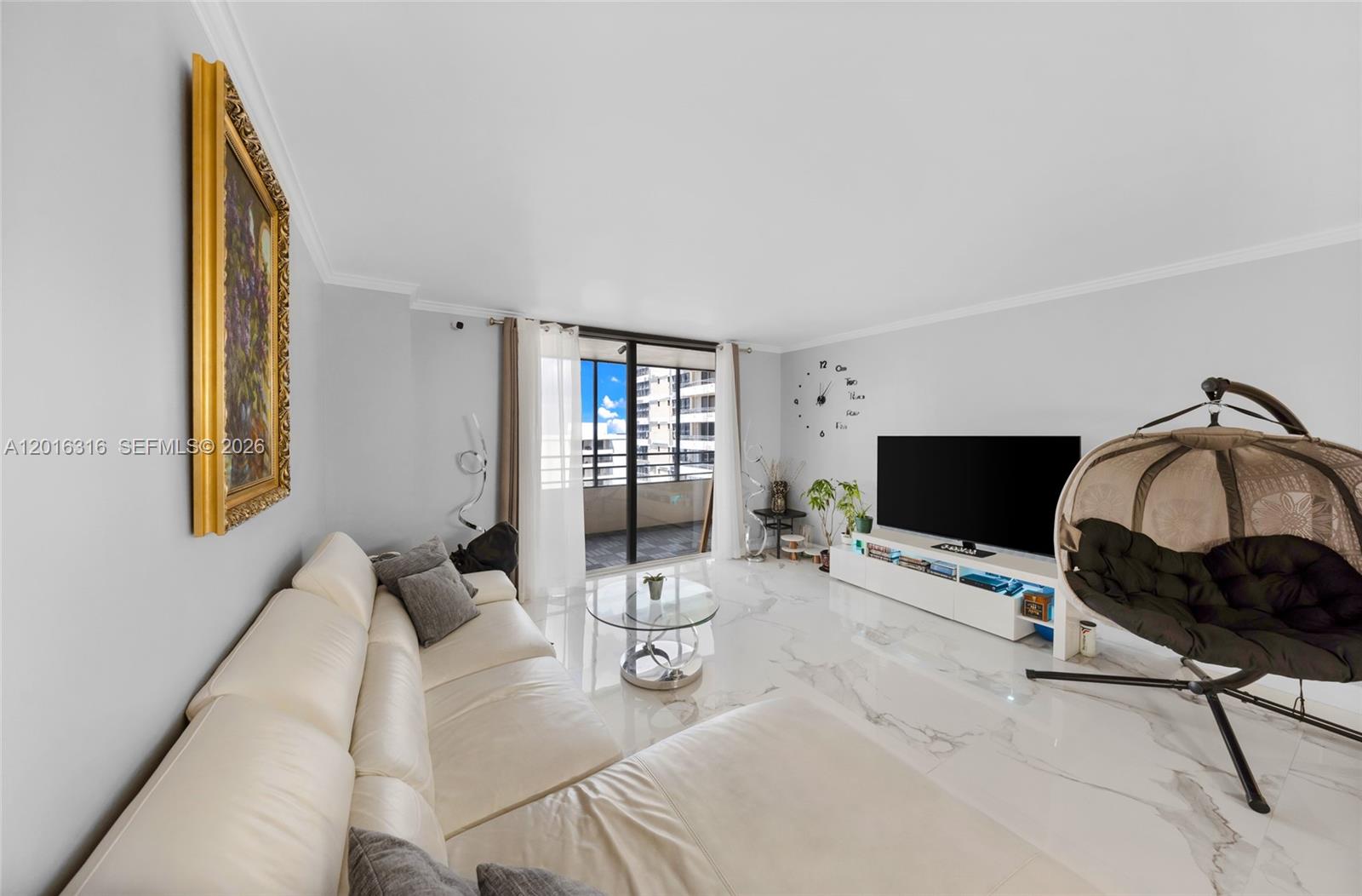 A living room features a white sectional sofa, marble floors, a television, and a hanging chair — 2500 Parkview Dr # 2119, Hallandale Beach FL 33009, HALLANDALE BEACH, FL