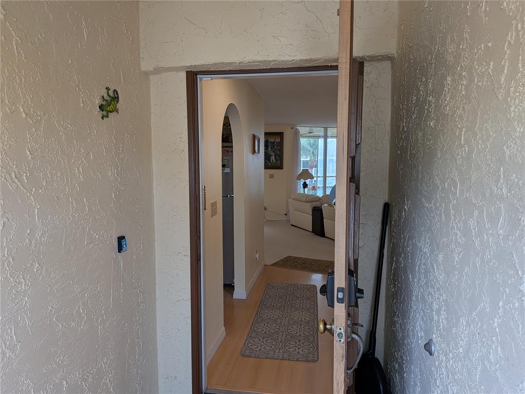 An open front door reveals a hallway leading into a living room with light flooring — 6101 34TH STREET W UNIT 31H, BRADENTON, FL