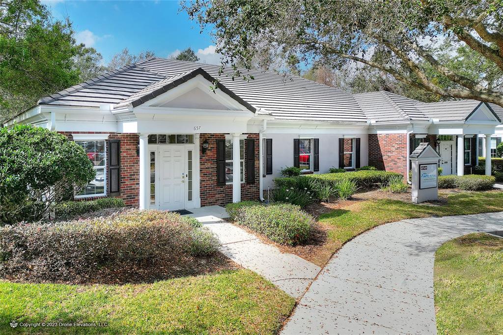 A single-story brick and stucco commercial building with a tiled roof and landscaped front yard — 657 W LUMSDEN ROAD, BRANDON, FL
