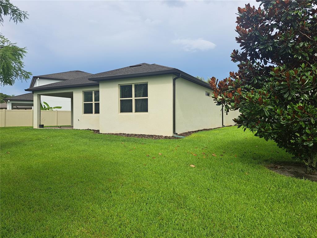 A view of the side and back exterior of a house with a covered patio — 2501 CIVITAS PLACE, CASSELBERRY, FL