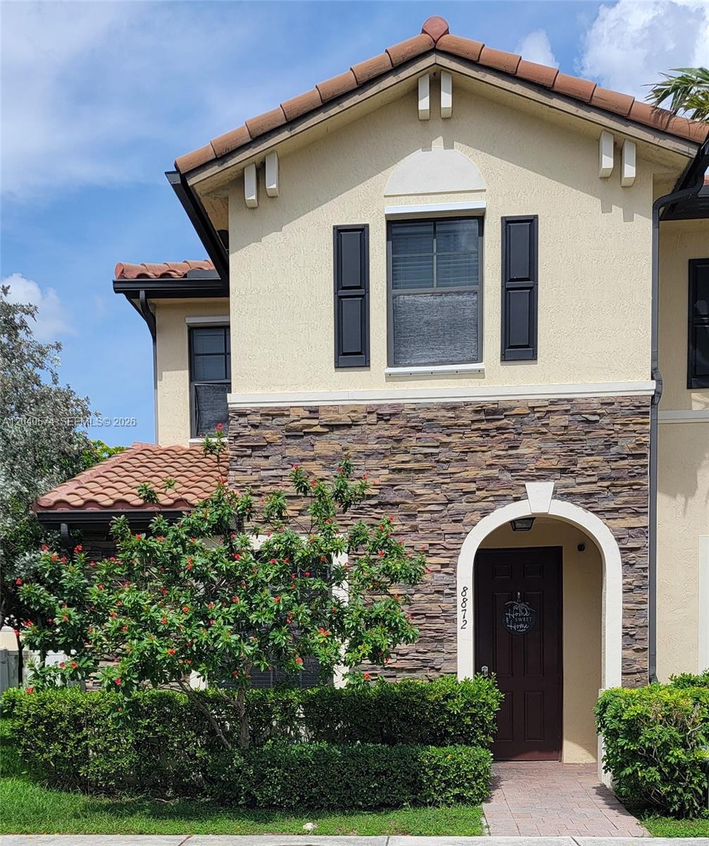 A two-story house exterior features a stone facade, a tiled roof, and a front entrance — 8872 W 35th Ct, Hialeah FL 33018, HIALEAH, FL