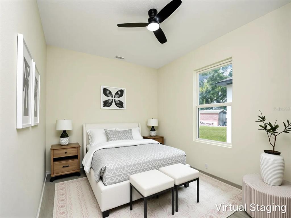 A bedroom with a bed, two nightstands, a ceiling fan, and a window — 2060 DIXIE AVENUE, SANFORD, FL