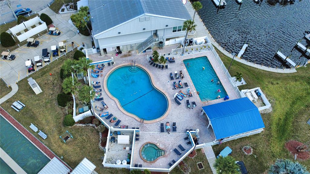 An aerial view shows a community pool area with two pools, a hot tub, and lounge chairs — 530 PARKWOOD AVENUE, NORTH PORT, FL