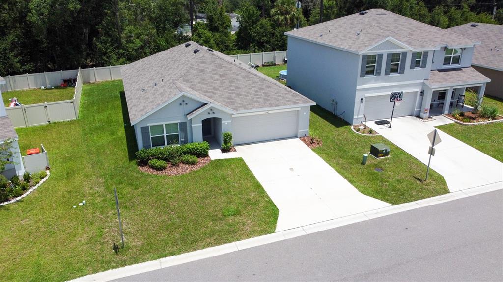 An aerial view shows two suburban houses with driveways, lawns, and vinyl fencing — 6747 SE 3RD LOOP, OCALA, FL