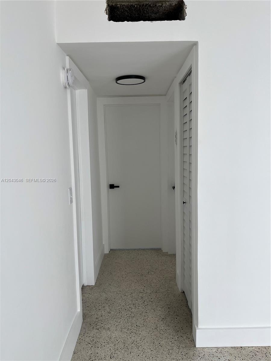 A narrow hallway features white walls, carpeted flooring, and a ceiling-mounted light fixture — 2010 SW 6th St # 4, Miami FL 33135, MIAMI, FL