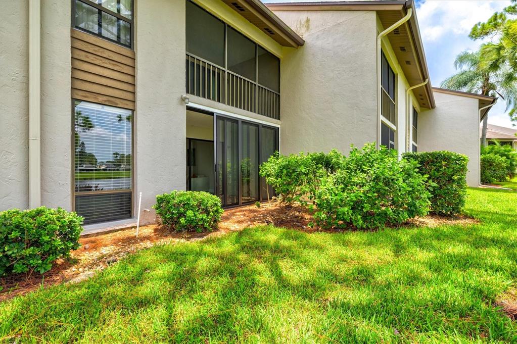 The exterior of a two-story residential building features a screened-in patio and landscaped lawn — 3053 TAYWOOD MEADOWS UNIT 3, SARASOTA, FL