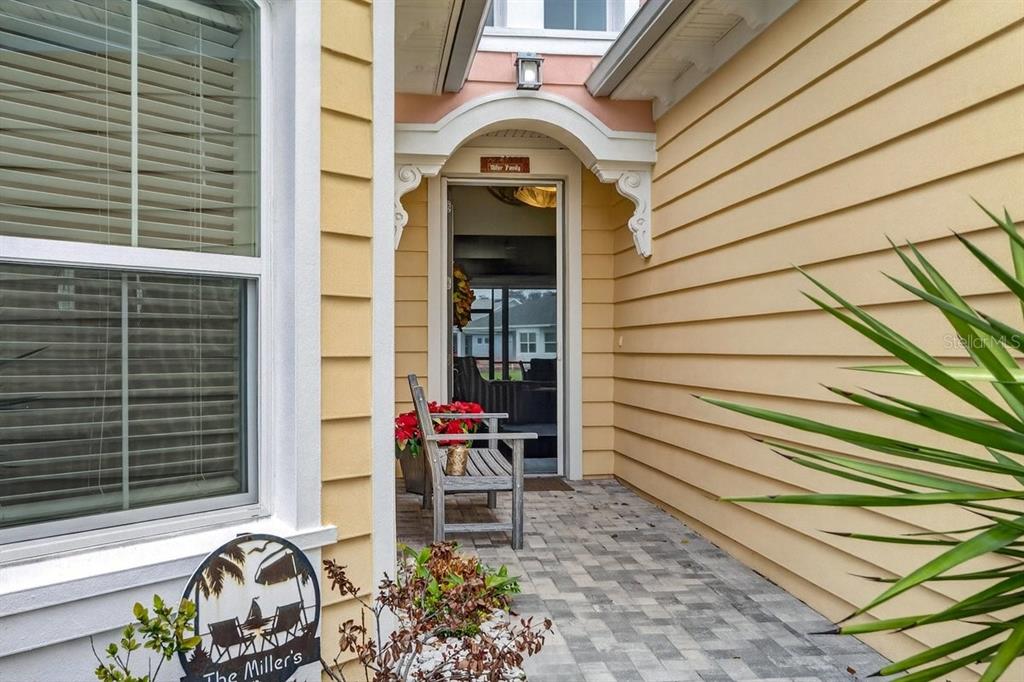A covered entryway features light yellow siding, a brick paver floor, and a wooden bench — 264 MARGARITAVILLE AVENUE, DAYTONA BEACH, FL