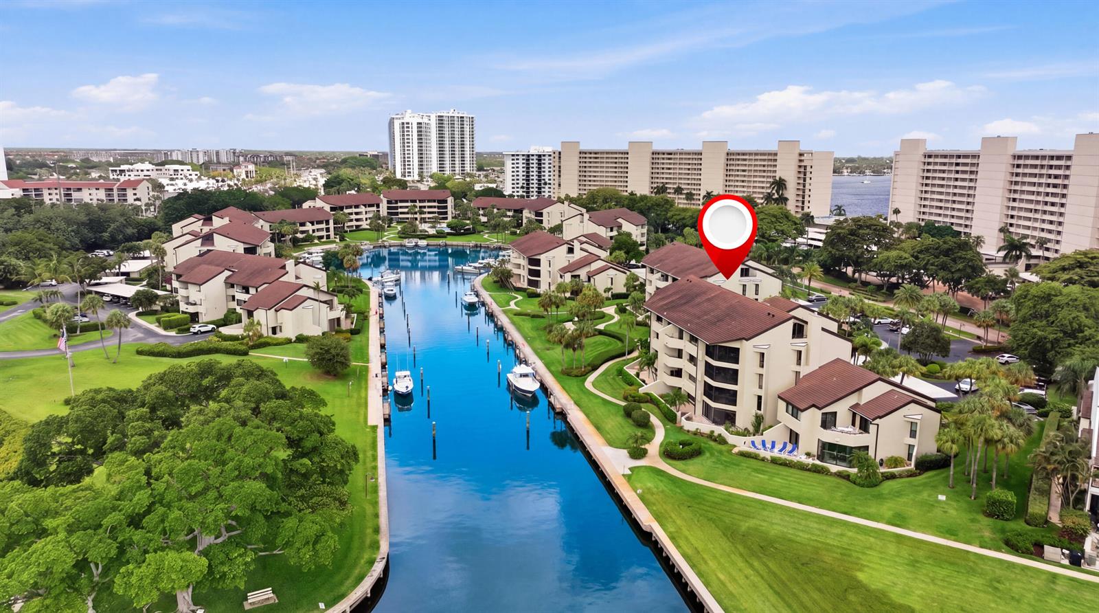 An aerial view shows a multi-story residential building complex situated along a narrow canal — 1109 E Marine Way E, North Palm Beach FL 33408, NORTH PALM BEACH, FL