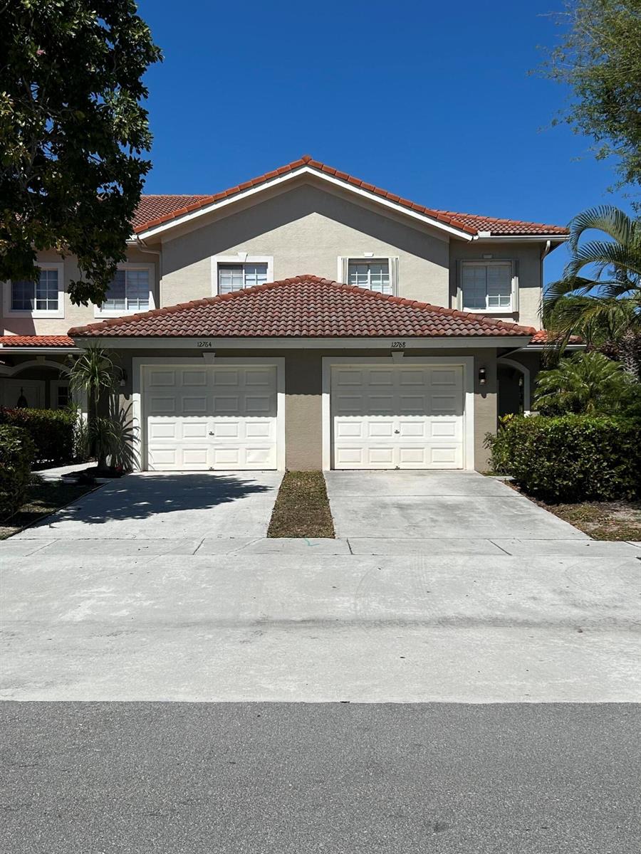 A two-story duplex with two white garage doors and a red tile roof — 12768 Westhampton Circle, Wellington FL 33414, WELLINGTON, FL