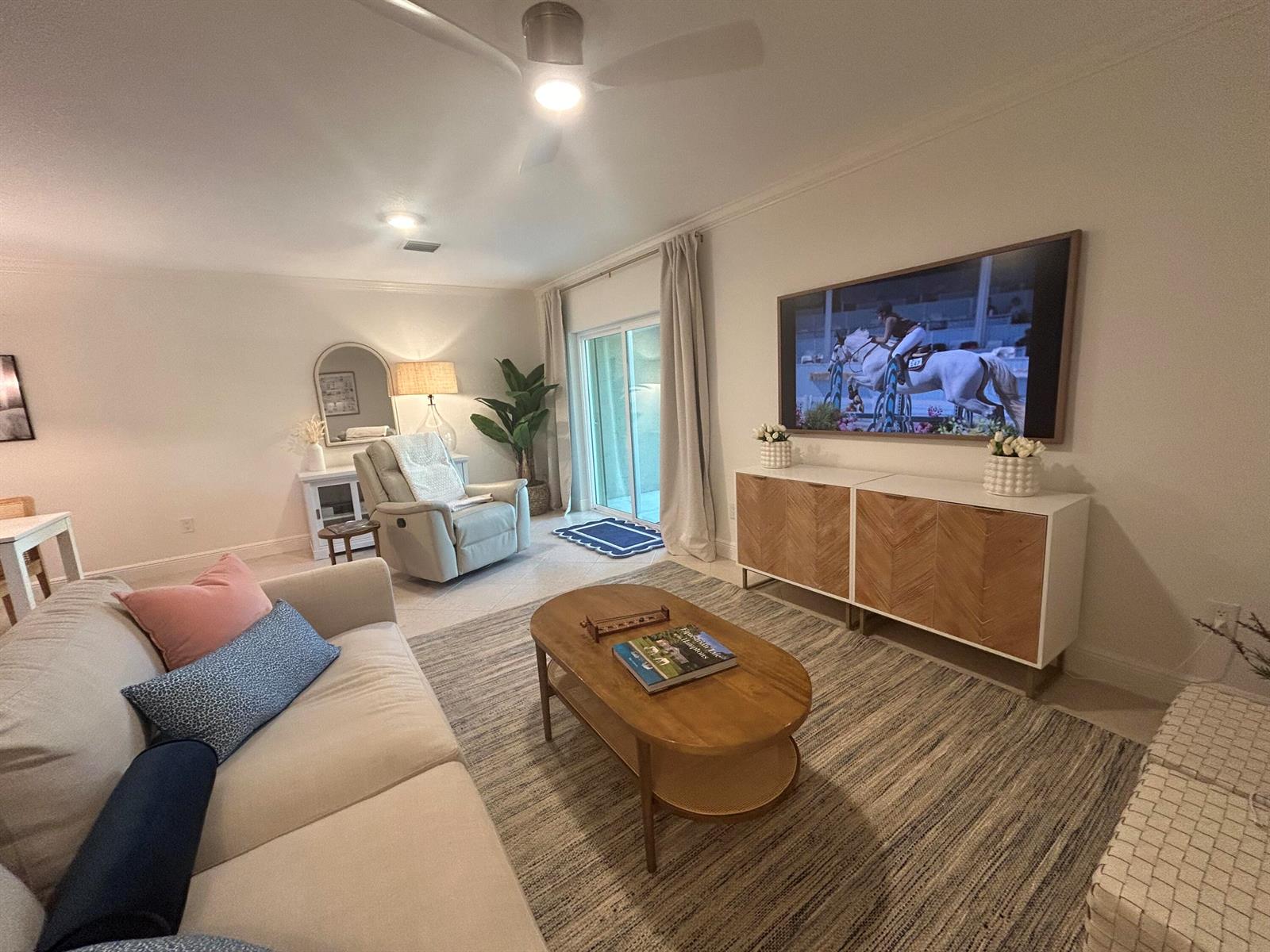 A living room features a beige sofa, wooden coffee table, media console, and a recliner — 12768 Westhampton Circle, Wellington FL 33414, WELLINGTON, FL